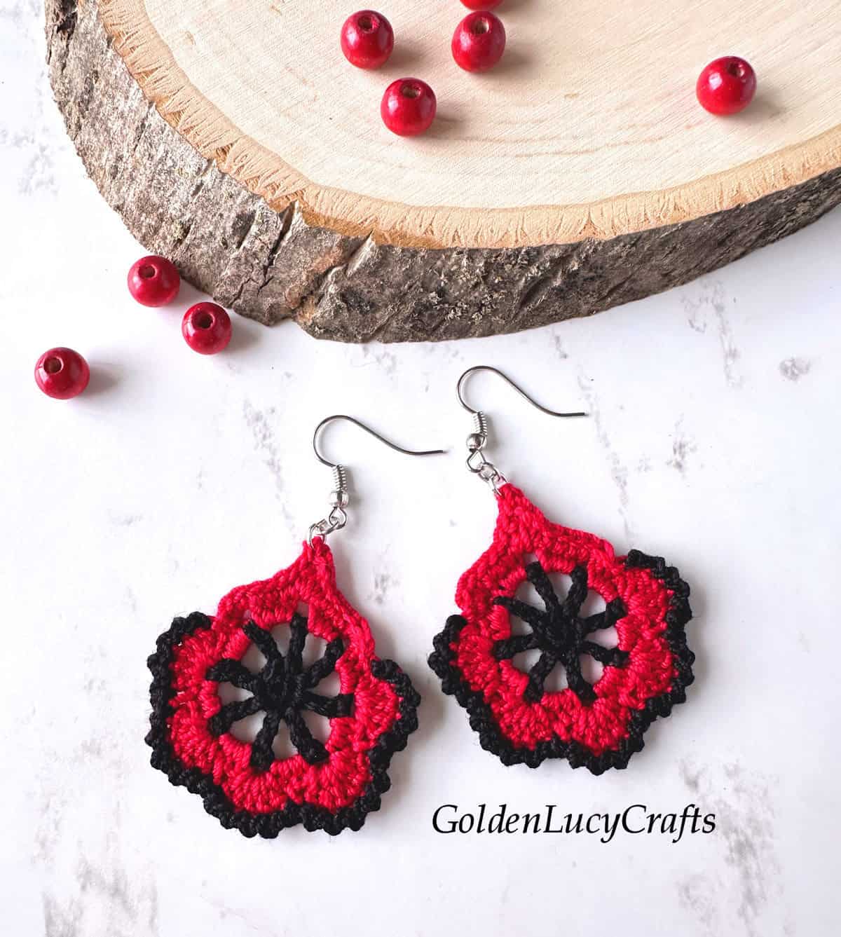 A pair of crocheted earrings in black and red.