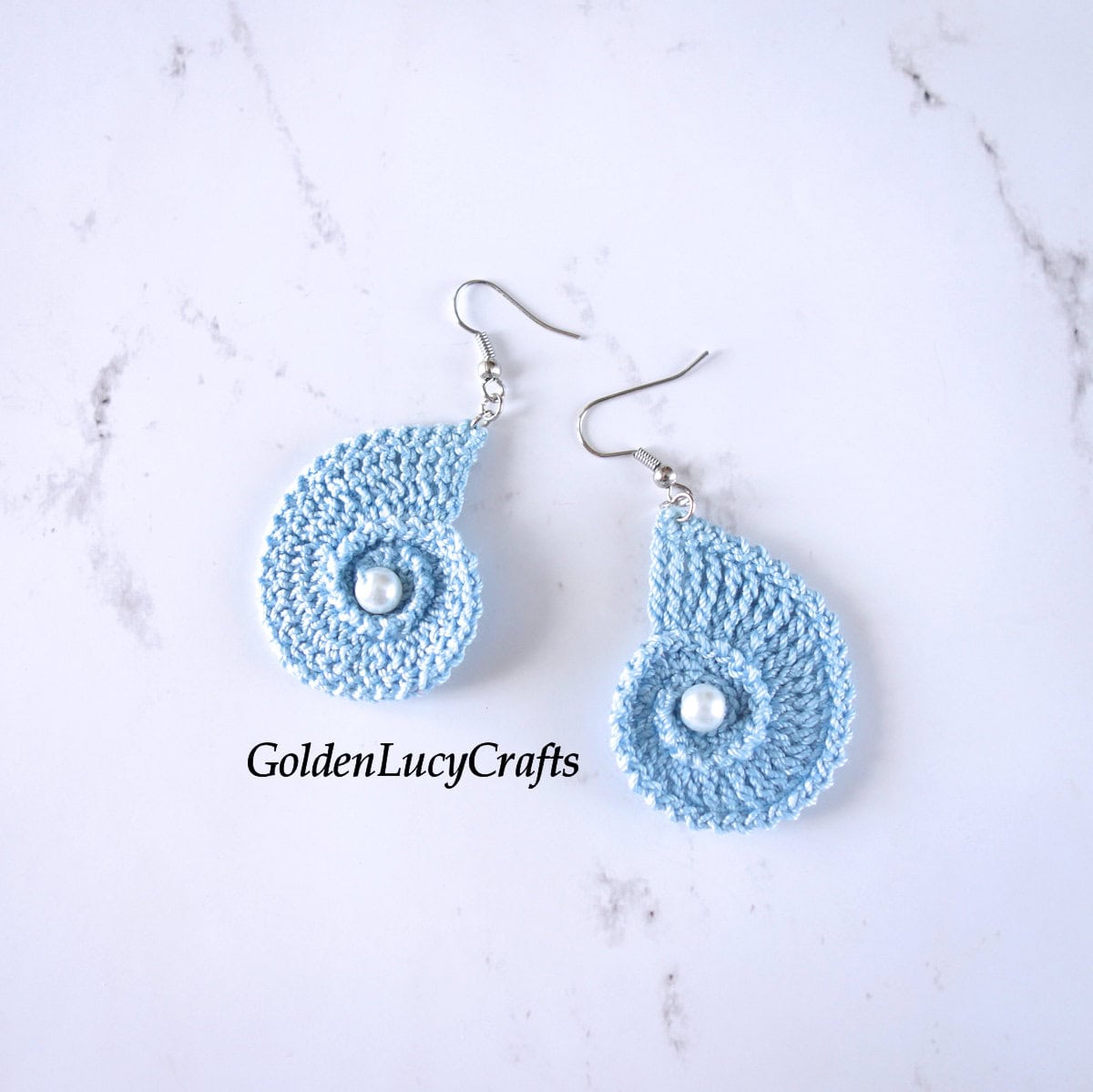 Crocheted light blue seashell earrings.