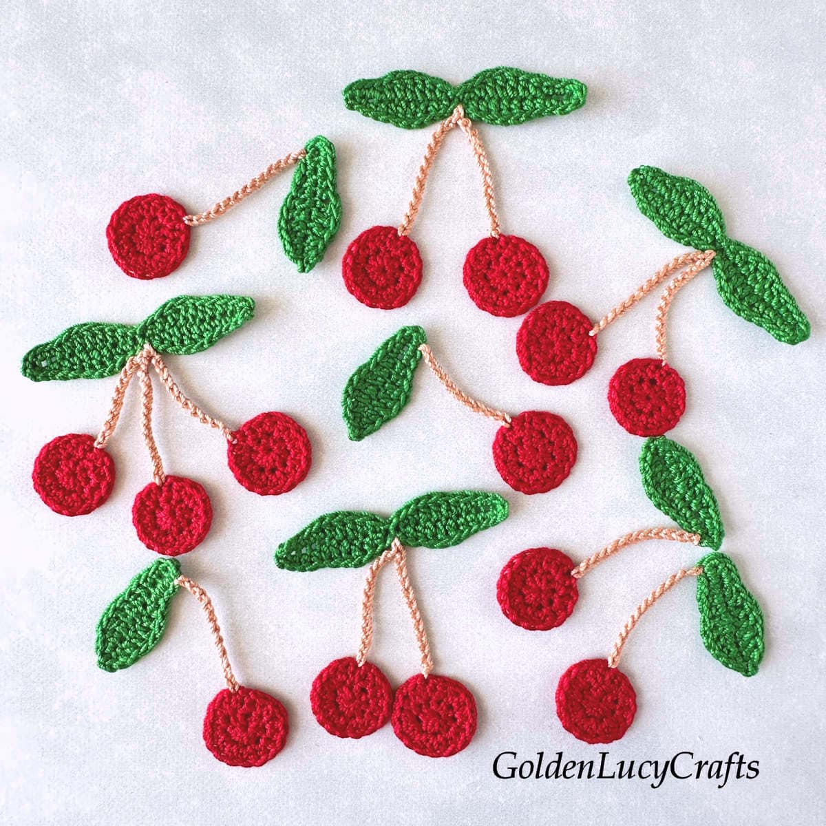 Crocheted red cherry appliques.