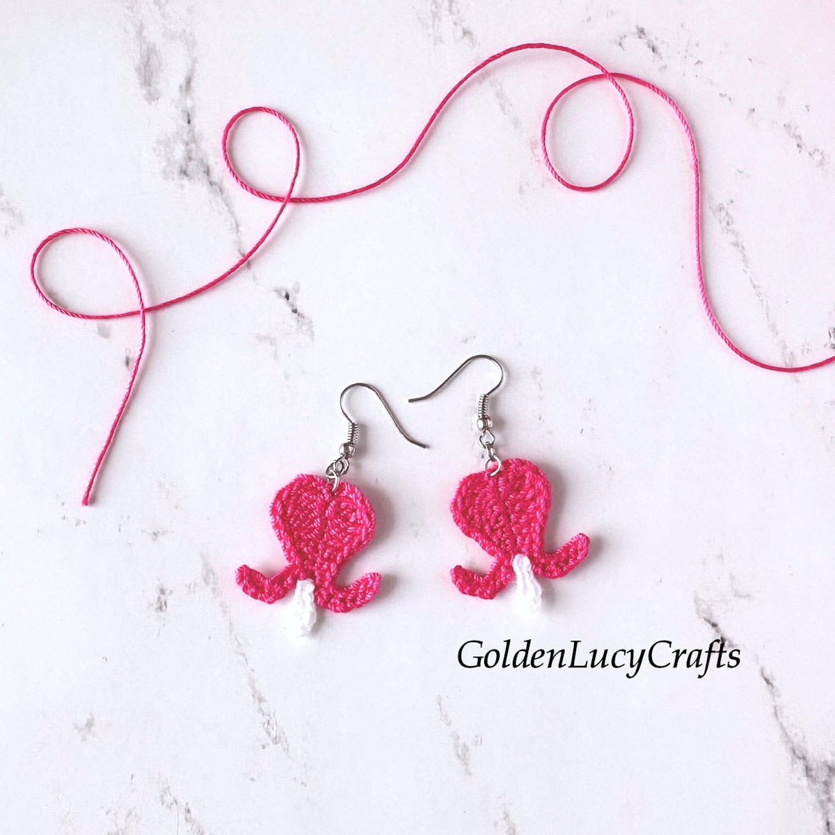 Crocheted bleeding heart flower earrings.