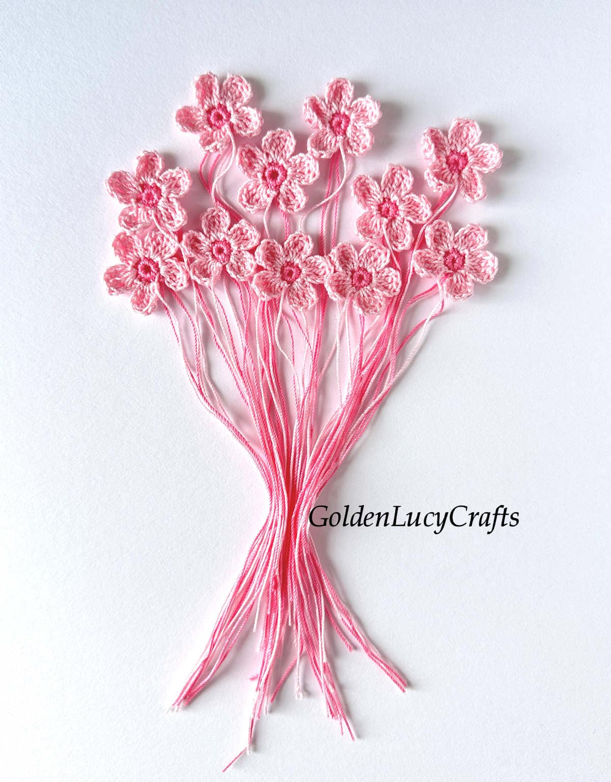 A bouquet made from crocheted pink cherry blossom flowers.
