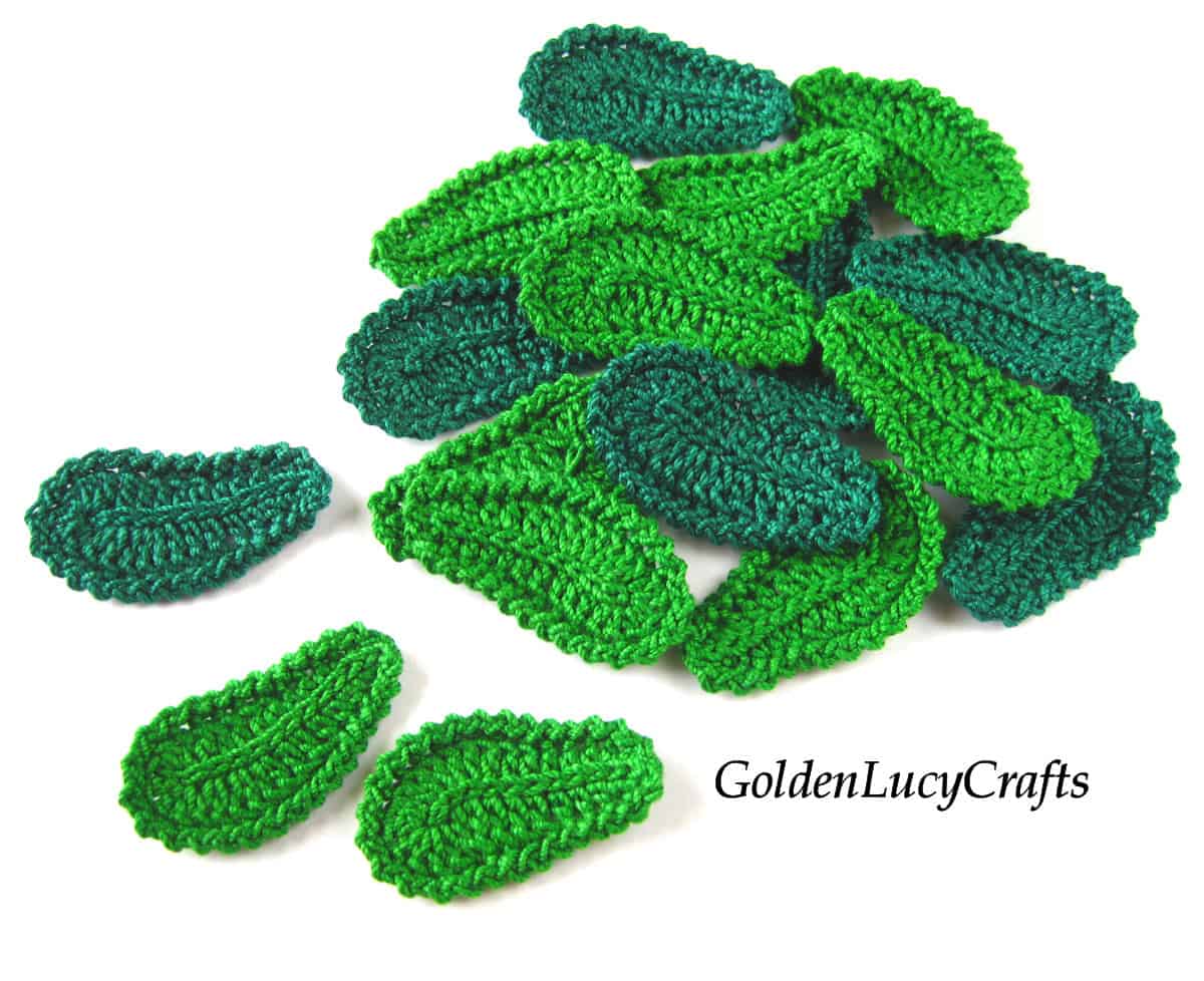 Pile of small crocheted green leaves.