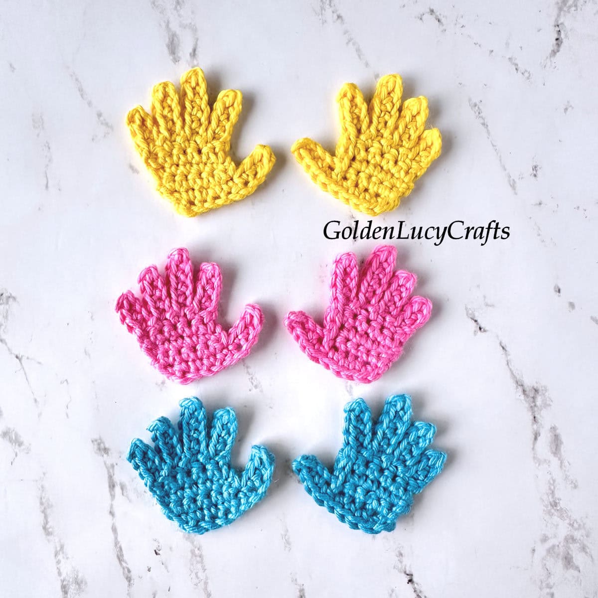 Three pairs of crocheted hand (or palm) appliques in yellow, pink, and blue.