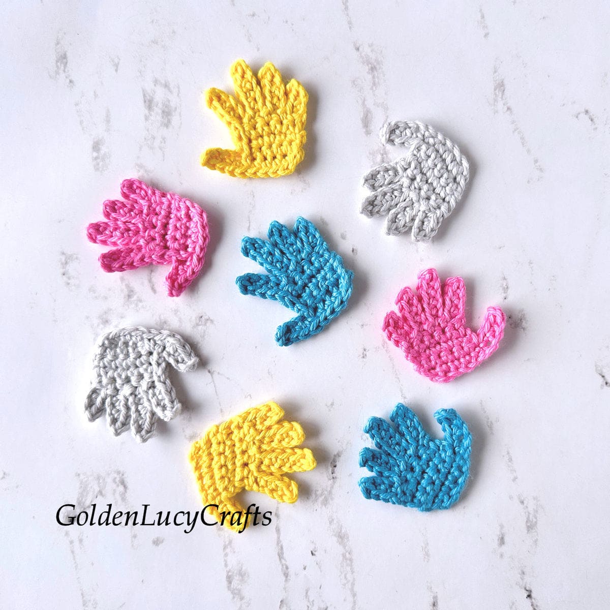 Crochet hand appliques in yellow, pink, blue, and gray colors.