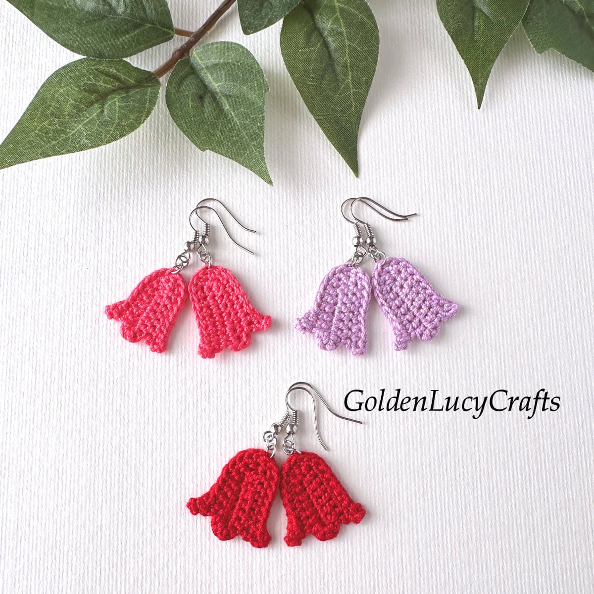 Three pairs of crocheted tulip earrings are laid out on a white background.