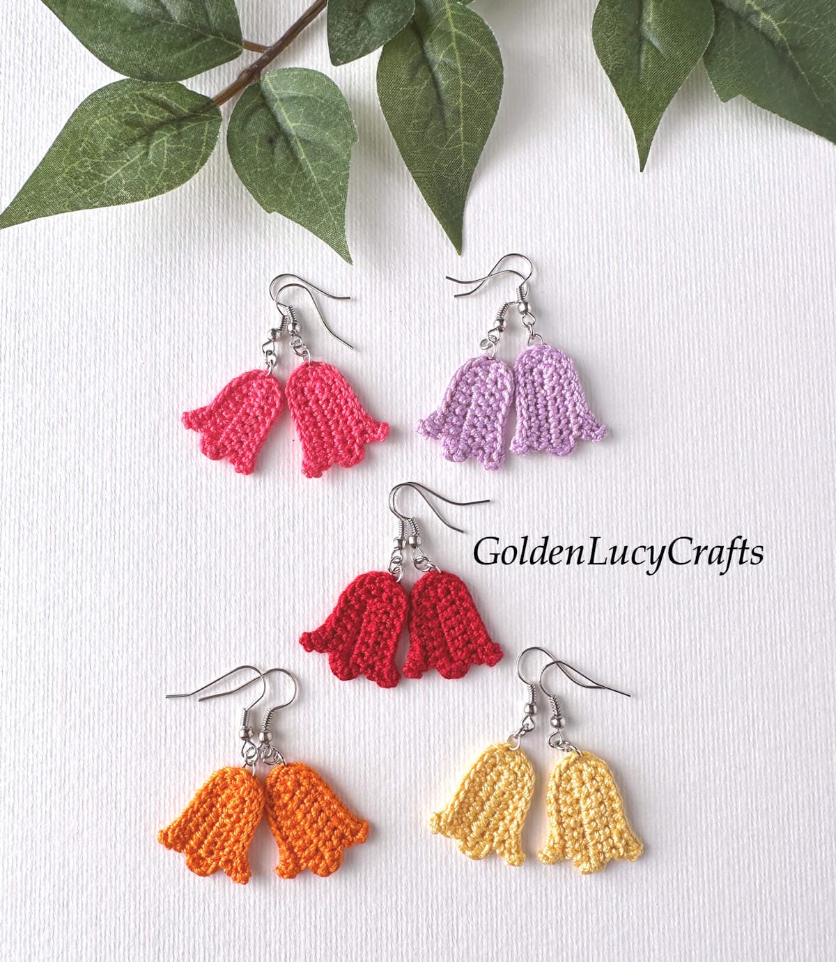 Five pairs of crocheted tulip earrings are laid out on a white background.