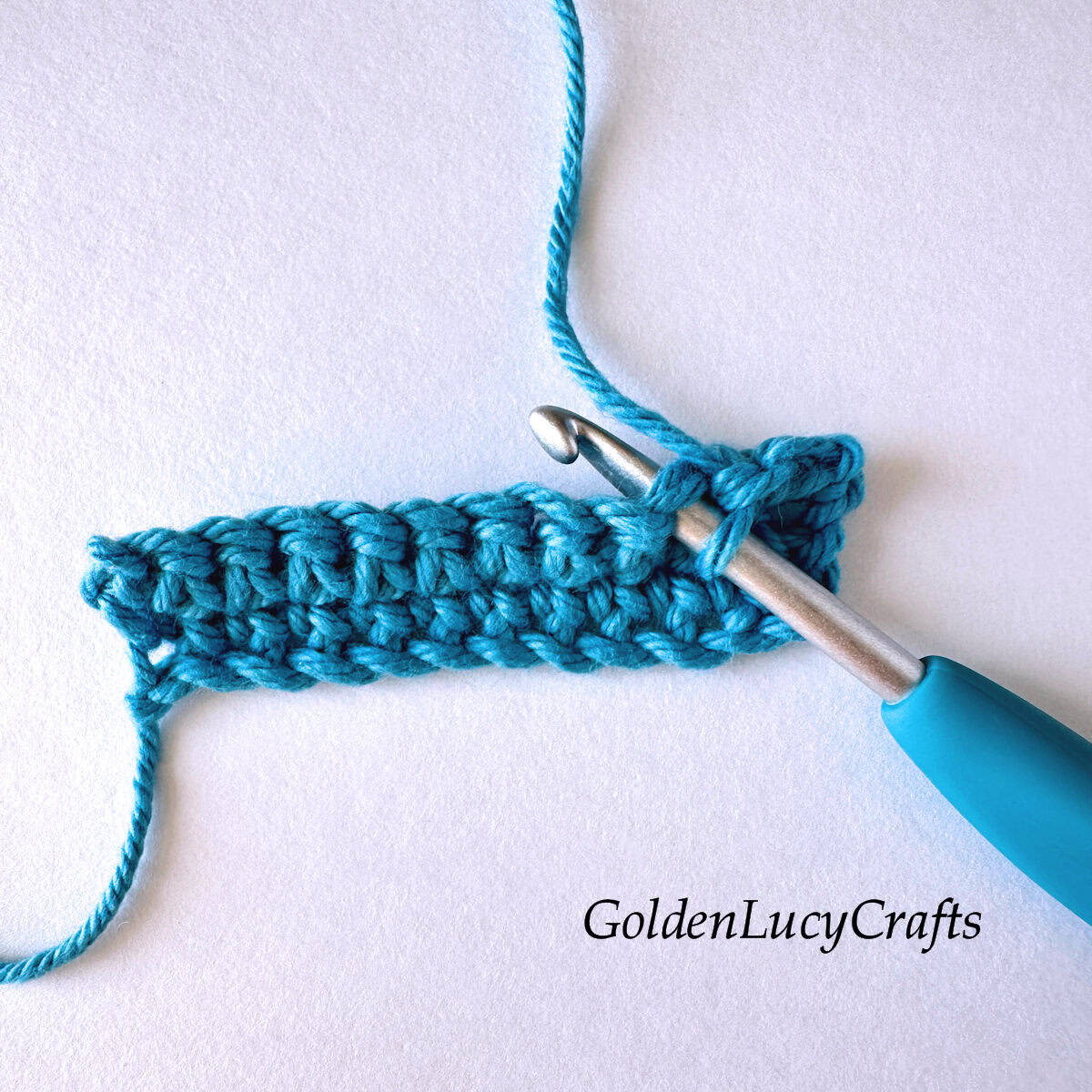 Crochet sample demonstrating Step 1 of how to work two single crochet stitches together.