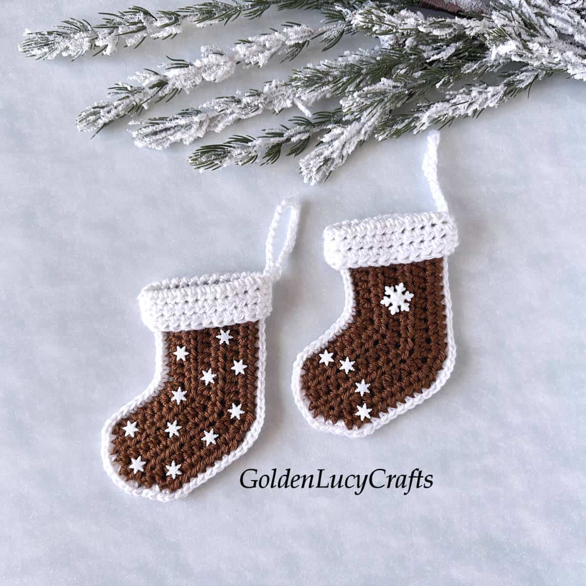 Two crocheted miniature gingerbread stockings.