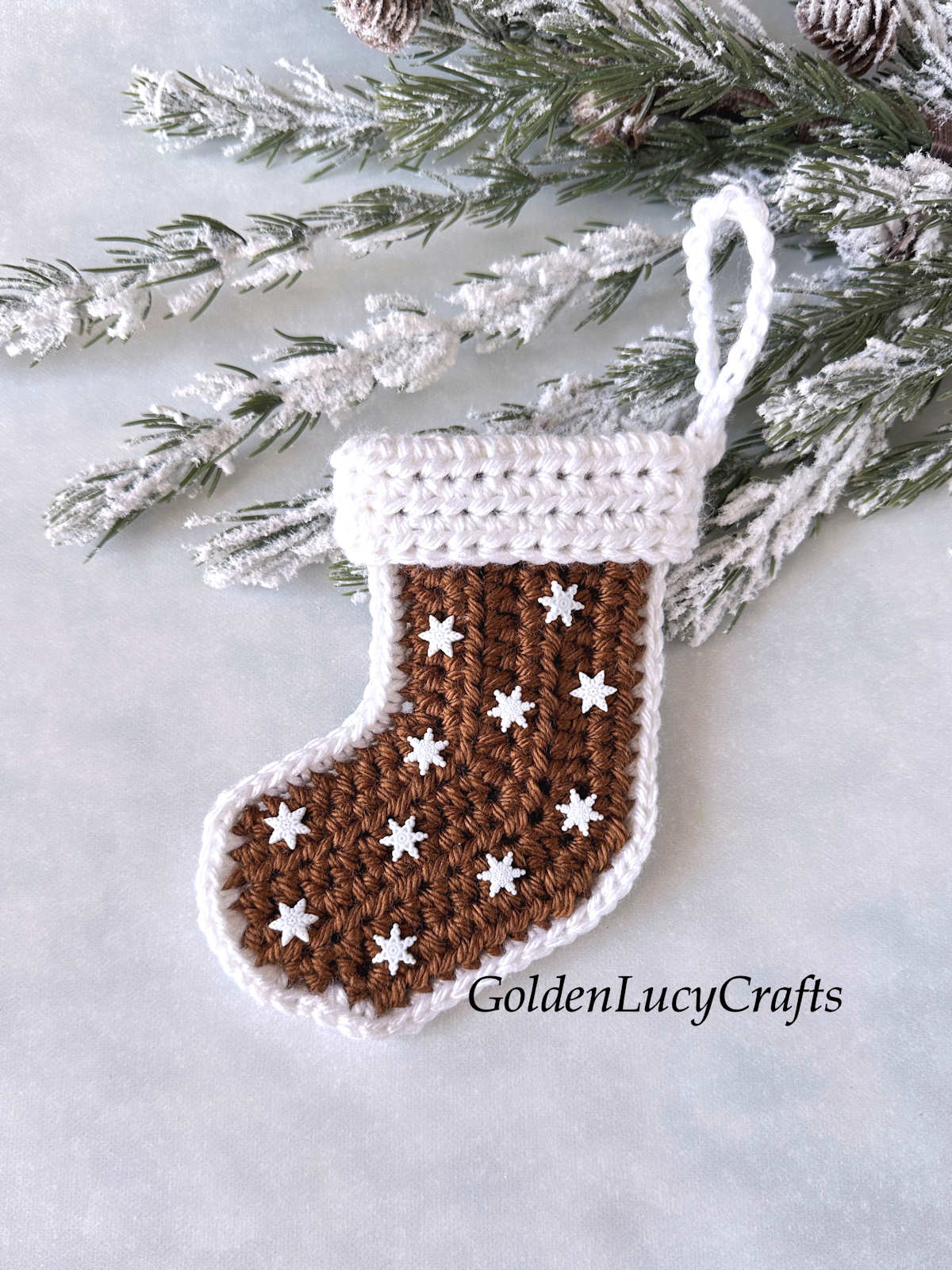 Crocheted Christmas stocking made in a gingerbread theme and embellished with small snowflake buttons.