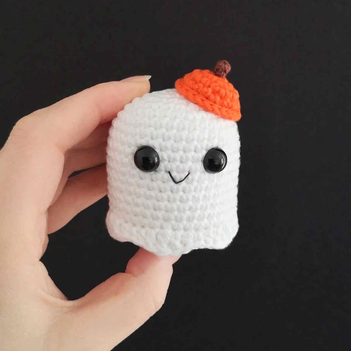 Crocheted white ghost in orange hat.