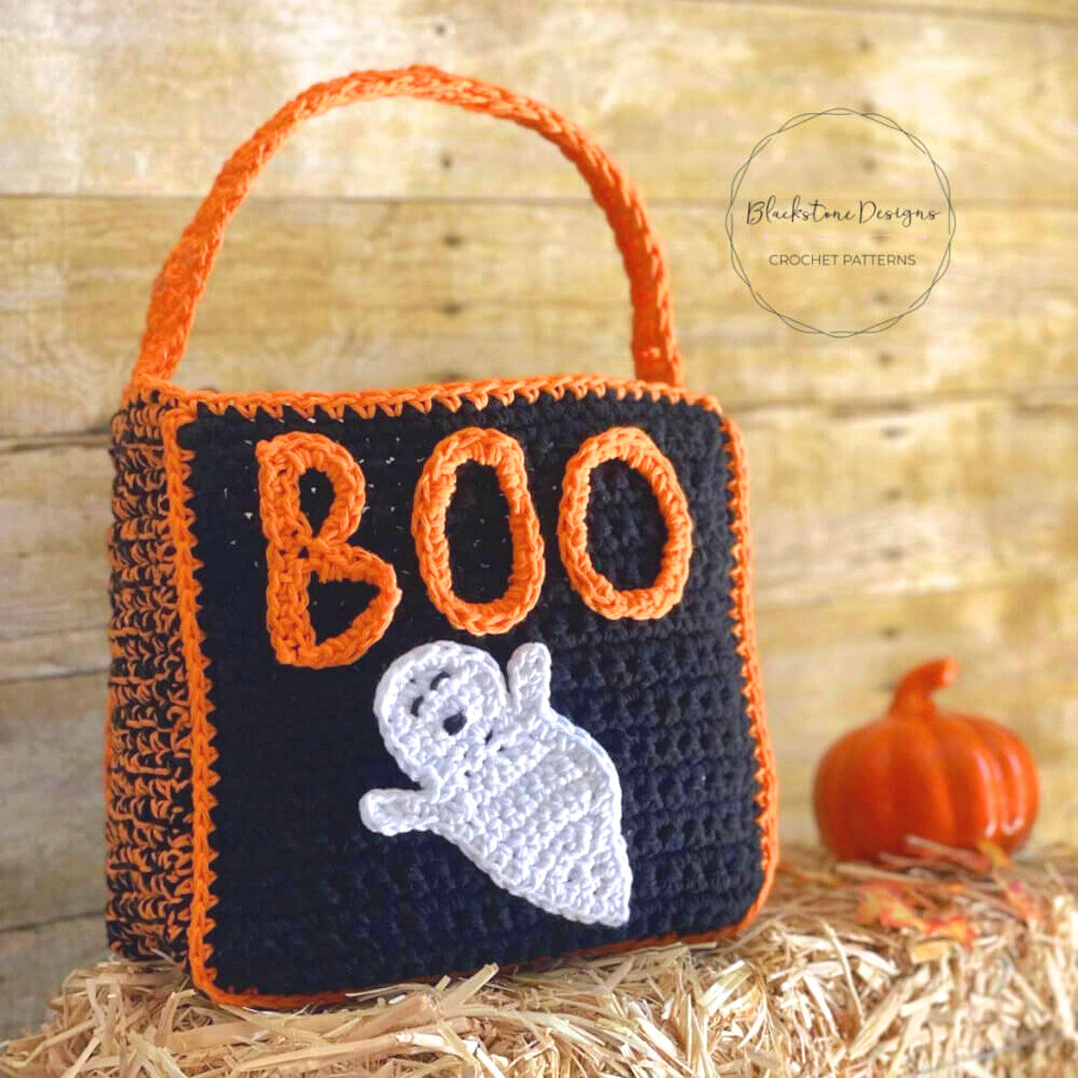 Crocheted black tote bag with orange letters BOO and white ghost applique.