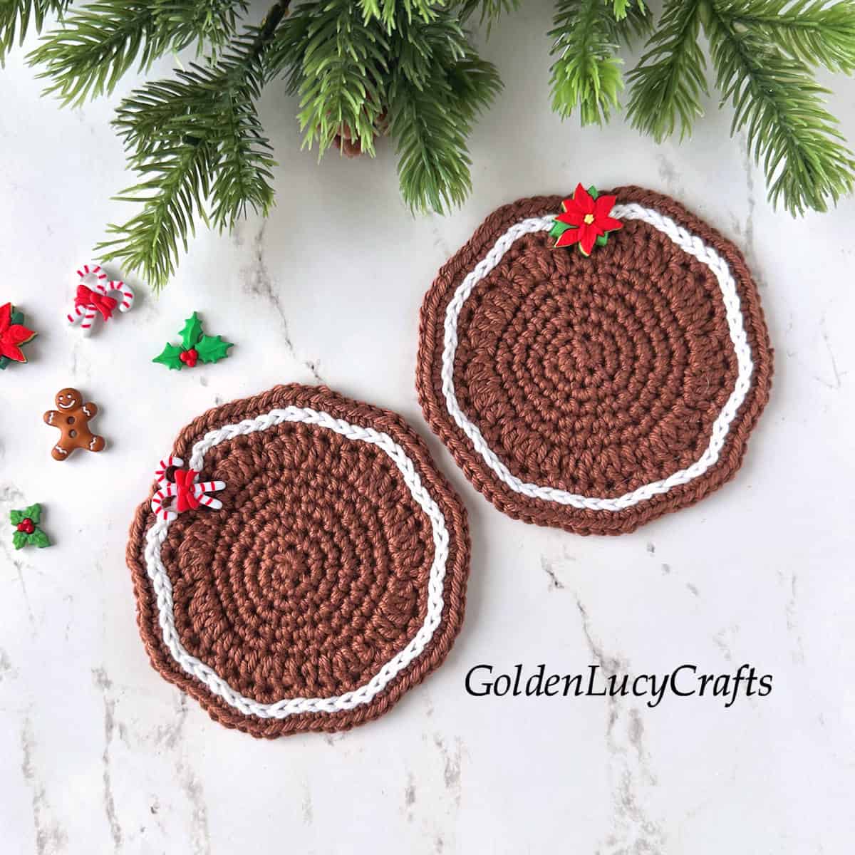 Two crocheted gingerbread-themed coasters in brown and white, embellished with Christmas decorative buttons.